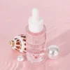 Bottle of Rose and Collagen Two-phase Face Serum with a seashell and pearls on a pink background.