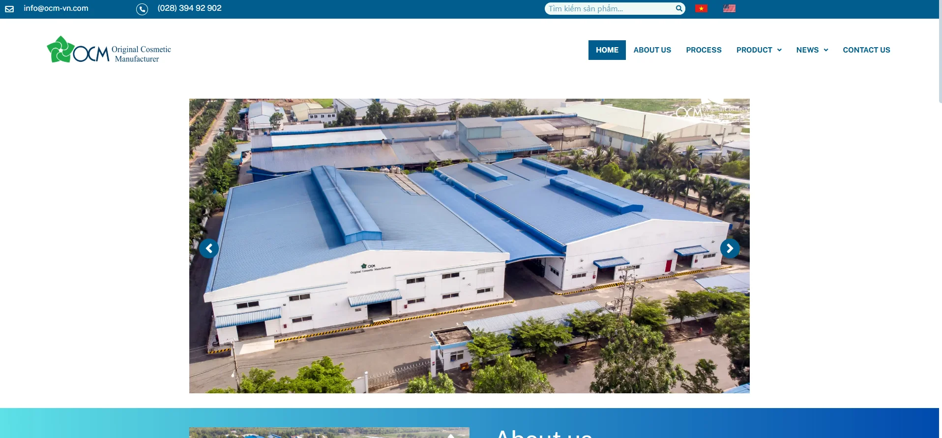 Aerial view of a cosmetic manufacturer facility with large blue-roofed buildings and surrounding greenery.