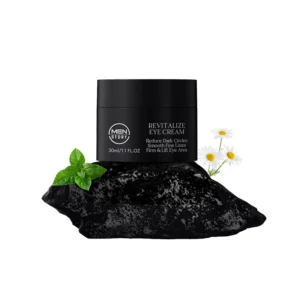 Men's eye cream on dark stone with mint leaves and daisies, suggesting natural ingredients and benefits for eye care.