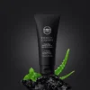 Men Story Energize Cleanser tube with aloe leaf and mint on a black stone background, promoting deep clean benefits.