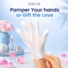 A hand wearing a moisturizing mask glove, surrounded by rose petals and spa accessories on a marble surface.