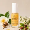 A bottle of XIRAN Dual-Phase Oil Honey Serum surrounded by natural ingredients like white camellia flowers and oil extracts.