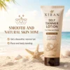 Tube of Xiran self-tanner lotion for medium to dark skin, placed on sandy beach with seashells and starfish in tropical coastal scenery.