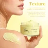 Close-up of a woman holding a jar of XIRAN CE Jam Body Scrub, with the scrub applied to her shoulder. Text describing texture is visible.