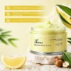 XIRAN CE Jam Body Scrub in a clear jar, surrounded by lemon slices, shea nuts, and leaves, highlighting exfoliation and brightening benefits.