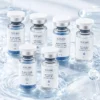 Six Xiran skincare vials featuring blue copper peptide repair and activating solution placed on a water-like reflective surface.