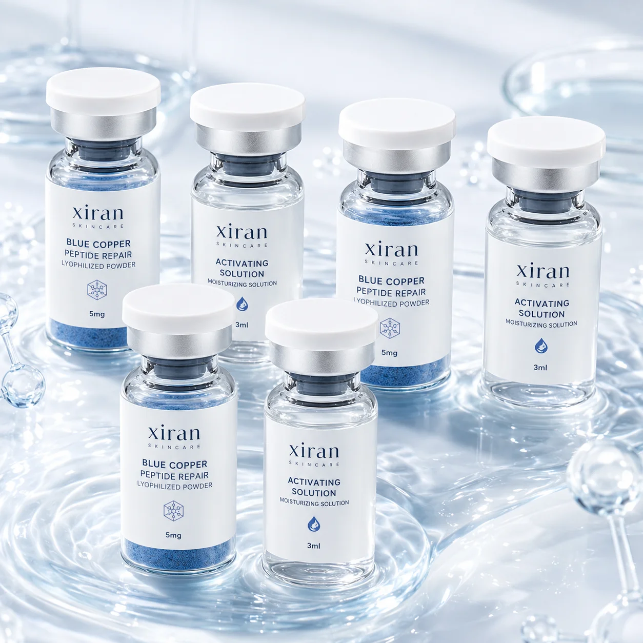 Six flacons de soin Xiran contenant une solution réparatrice et activatrice à base de peptide de cuivre bleu, placés sur une surface réfléchissante semblable à de l'eau.