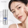 A woman with glowing skin touching her face, next to a bottle of anti-wrinkle serum oil labeled 'Volufine Plumping & Repair'.