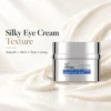 Silky eye cream with a rich, smooth texture in a silver jar. Promoted as plumping, firming, and non-greasy, with a background of cream texture.