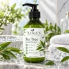 Green bottle of Xiran tea tree conditioner with pump, surrounded by water droplets, tea tree leaves, and towels in a bright natural setting.