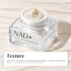 A close-up of a jar of NAD+ firming and line-smoothing bandage cream with a rich, creamy texture in a clear glass container.